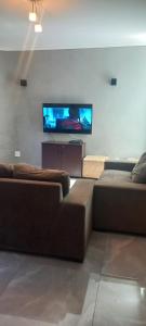 a living room with two couches and a flat screen tv at Casa Flórida in Uberaba