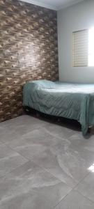 a bed in a room with a stone wall at Casa Flórida in Uberaba