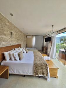 a bedroom with a large white bed and a large window at Euetu na Lapinha da Serra in Santana do Riacho