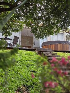 a view of a house from the grass with a bench at Euetu na Lapinha da Serra in Santana do Riacho