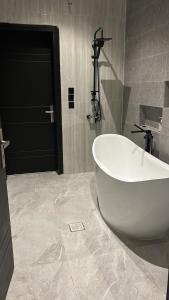 a bathroom with a white tub and a black door at شاليه السيل الكبير in As Sayl al Kabīr +16 photos