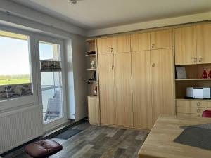 a kitchen with wooden cabinets and a large window at Tief 10 Neptun mit Internet 607 in Wangerland +50 photos
