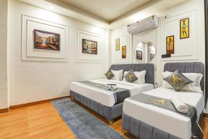 a bedroom with two beds and a mirror at Hotel The Arrow International Laxmi Nagar in New Delhi
