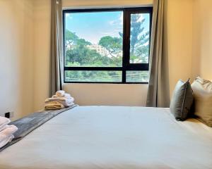 a bedroom with a large bed with a window at Neptune Luxe in Nairobi +38 photos