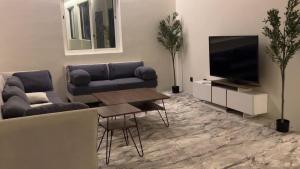 a living room with a couch and a television at شاليه السيل الكبير in As Sayl al Kabīr