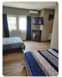 a hotel room with two beds and a flat screen tv at apartamento terracota in Tegucigalpa
