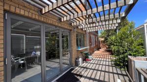 a pergola on a house with a patio at Cape one guest house in Welgelegen