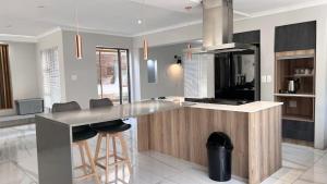 a kitchen with a counter with stools in a room at Cape one guest house in Welgelegen