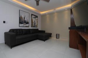 a living room with a black couch and a piano at Hotel Soberanis in Cancún