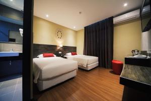 Habitación de hotel con 2 camas y lavamanos en Rooms, en Tawau