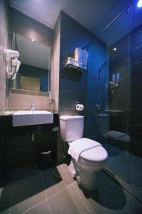 a bathroom with a toilet and a sink at Rooms in Tawau