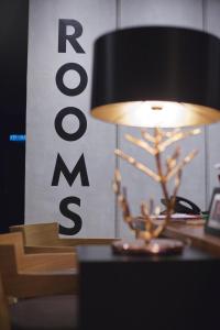 una lámpara sentada en un escritorio junto a una señal en Rooms, en Tawau