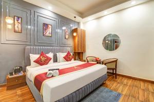 a bedroom with a large bed and a table at Hotel The Arrow International Laxmi Nagar in New Delhi +26 photos
