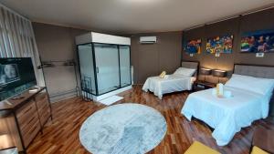 a hotel room with two beds and a television at The Halfway Cafe-Dauin, Glamp2 - Grasshopper in Dauin