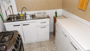 a small kitchen with a sink and a stove at casa completa Balmaceda 77 in Concepción