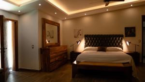 a bedroom with a bed and a dresser and a mirror at Quinta San Ignacio in Guadalajara