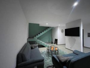 a living room with a couch and a staircase at Blanquila Resort in Willemstad