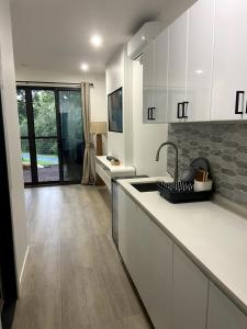 a kitchen with white cabinets and a sink at Sunset Ridge - King Bed Cabin & Breakfast Basket in Boyland