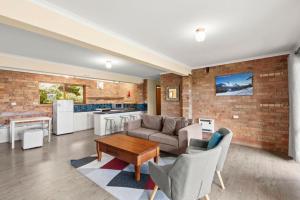 a living room with a brick wall at Winterwood 9 Camira Ave in Jindabyne
