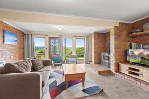 a living room with a brick wall at Winterwood 9 Camira Ave in Jindabyne