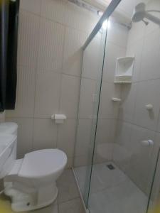 a bathroom with a toilet and a glass shower at Mini suíte Atitude no coração de Maragogi in Maragogi