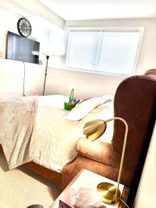 a bedroom with a bed and a table with a lamp at Room in niagara falls Pluto studio in Niagara Falls