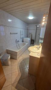 a bathroom with a tub and a toilet and a sink at Suite Calli in Bernburg