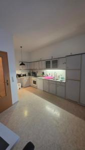 a large kitchen with white cabinets and appliances at Suite Calli in Bernburg +2 photos