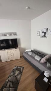 a living room with a bed and a tv at Suite Calli in Bernburg