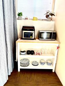 a microwave sitting on top of a shelf next to a window at Room in niagara falls Pluto studio in Niagara Falls +8 photos