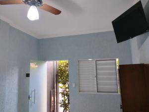 a ceiling fan and a window in a room at Pousada sushi-lazer in Casa Branca