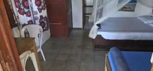 a bedroom with a bed and a table and chair at MAHAMBO BEACH hôtel in Mahambo