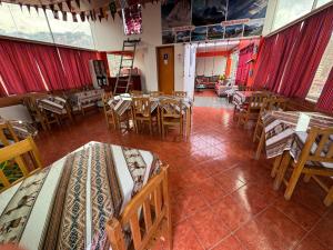 a dining room with tables and chairs and red curtains at Lhotse Hostel B&B in Huaraz