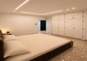 a large bedroom with a large bed and white cabinets at Dar Essalam - Mostaganem, Salamandre in Mostaganem