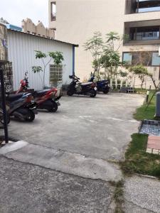 a group of motorcycles parked in a parking lot at 小魷魚輕旅 in Xiaoliuqiu