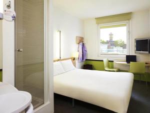 a hotel room with a white bed and a window at ibis budget Katowice Centrum in Katowice