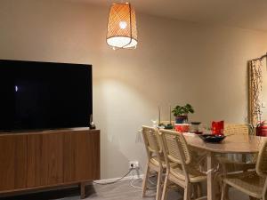 a dining room with a table and a flat screen tv at Eskias2 in Garðabær