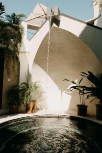 a swimming pool with a water fountain in a house at Caracola Boutique Hostel in El Paredón Buena Vista