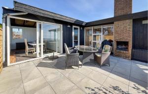 a patio with a table and chairs and a fireplace at Beautiful Home In Haderslev With Wifi in Haderslev +18 photos