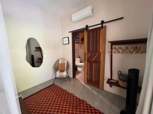 a hallway with a bathroom with a toilet and a door at Casa Gemini in Ilha de Boipeba