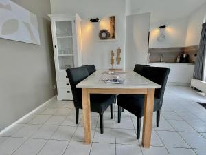 a dining room with a wooden table and black chairs at Aquaronde 117 in Lemmer