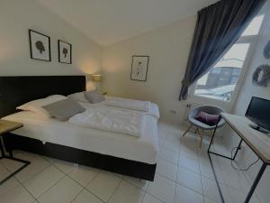 a bedroom with a large bed with a desk and a window at Aquaronde 117 in Lemmer