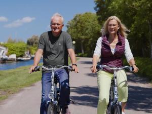 a man and a woman riding bikes down a path at Aquaronde 117 in Lemmer