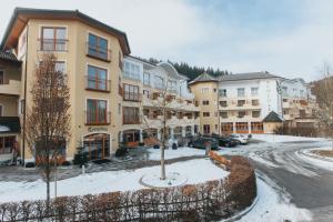 a apartment building with snow on the ground at Wellnesshotel Aumühle in Grein