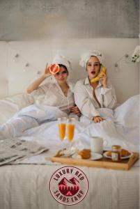 two people laying in bed with food and drinks at Rum Rhal Luxury Camp in Aqaba