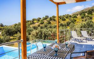 a patio with a table and chairs and a swimming pool at Thyme 1 in Agia Galini +10 photos