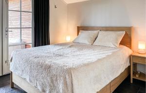 a bedroom with a large bed and a window at Buitengoed Het Lageveld - 56 in Hoge-Hexel +12 photos