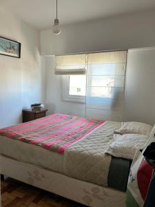 a bedroom with a large bed with a striped blanket at Cálido y luminoso hogar in Vicente López