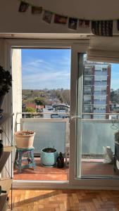 an open door to a balcony with a view at Cálido y luminoso hogar in Vicente López