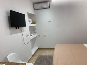 a room with a table and a tv on the wall at Holiday Home in Shkodër